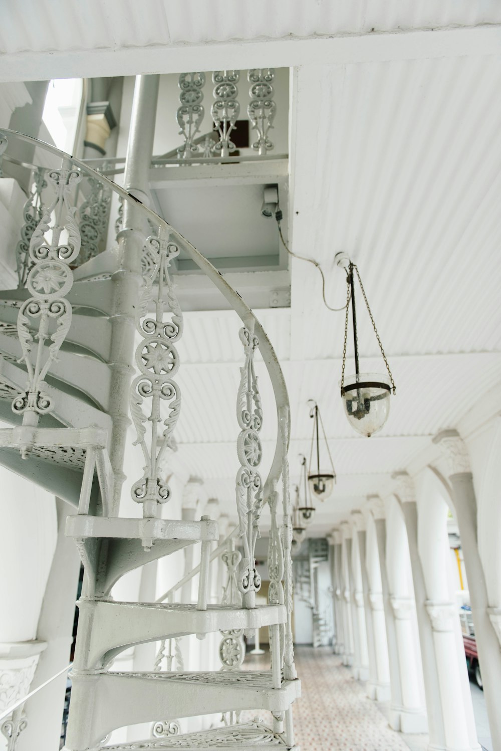 white spiral stairs near pendant lamp