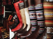 Rows of colorful custom boots lined up, showcasing different designs and leathers.