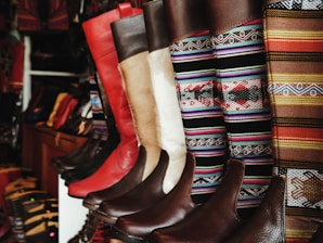 A collection of stylish boots displayed on a rustic wooden surface.