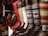 A collection of colorful and intricately designed boots are displayed, featuring a variety of leather textures and vibrant woven patterns. The boots range from solid red and brown leather to multicolored geometric designs, creating an eclectic and artisanal aesthetic.