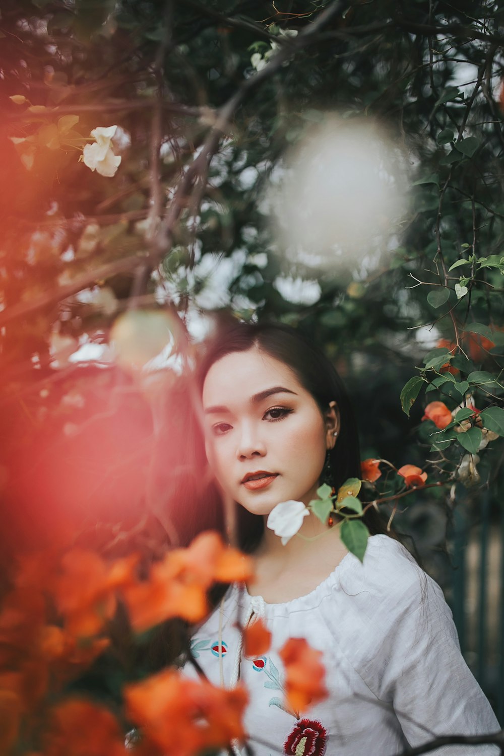 selective focus photo of woman wearing white top beside trees