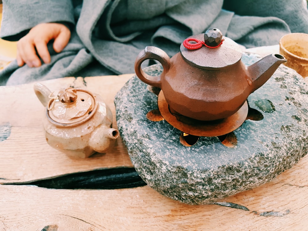 brown clay teapot on heated stone