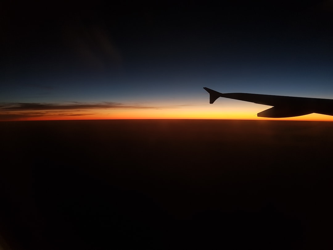 silhouette photograph of plane wing during golden hour,