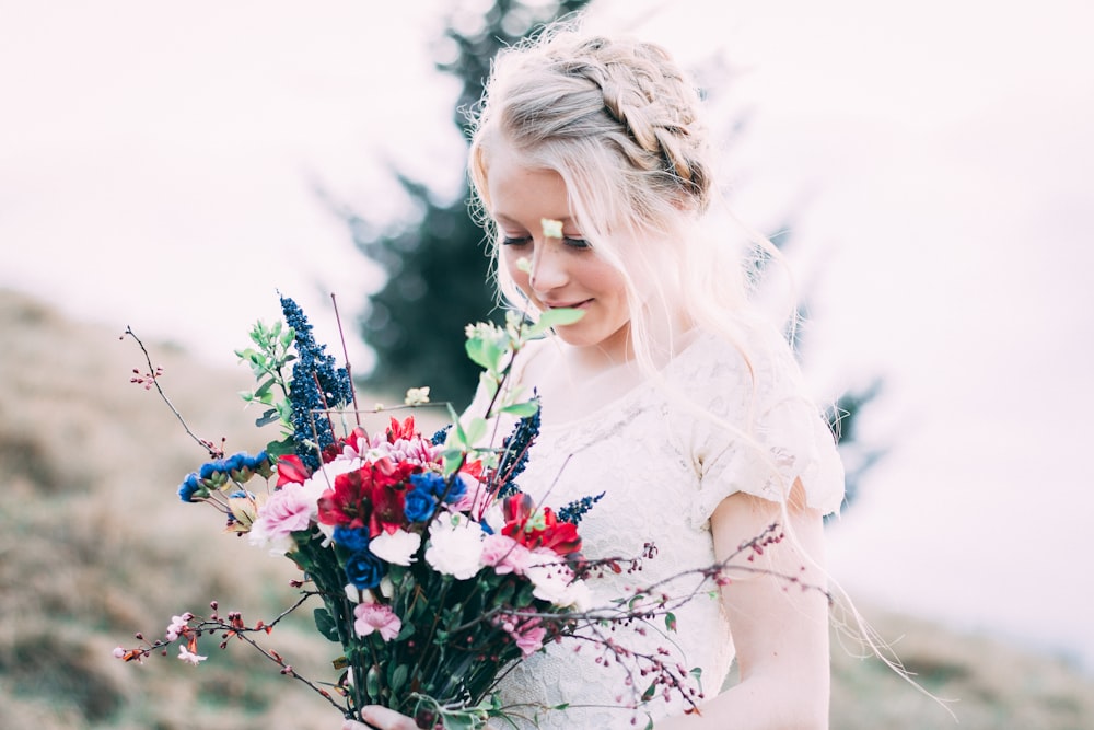 ragazza che tiene mazzo di fiori