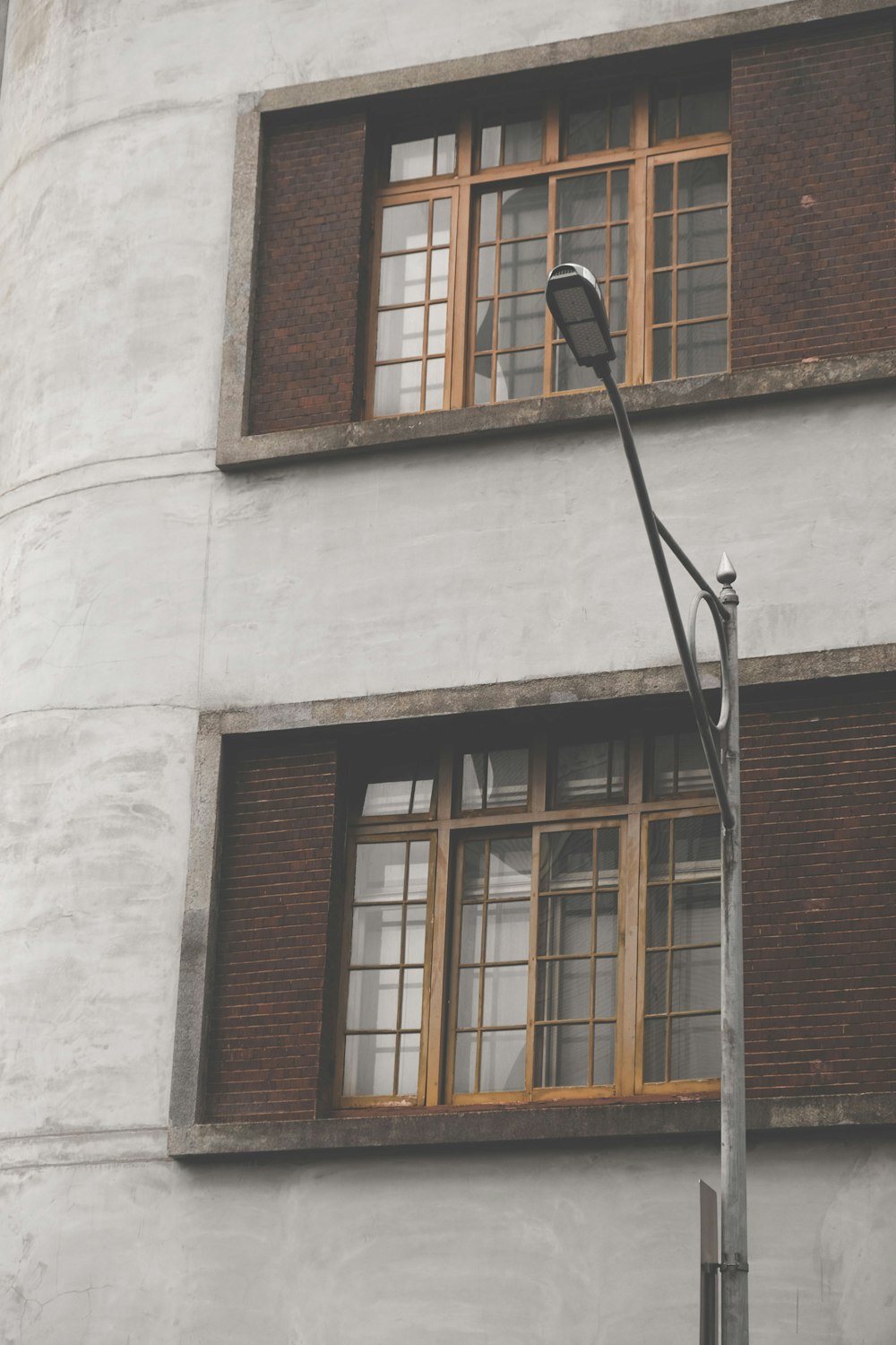 灰色のコンクリートの建物の近くの屋外郵便灯の写真