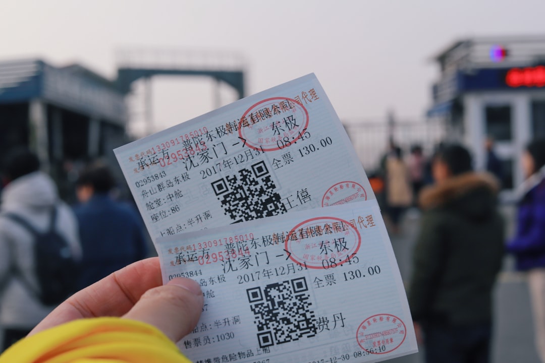 person holding two white tickets,