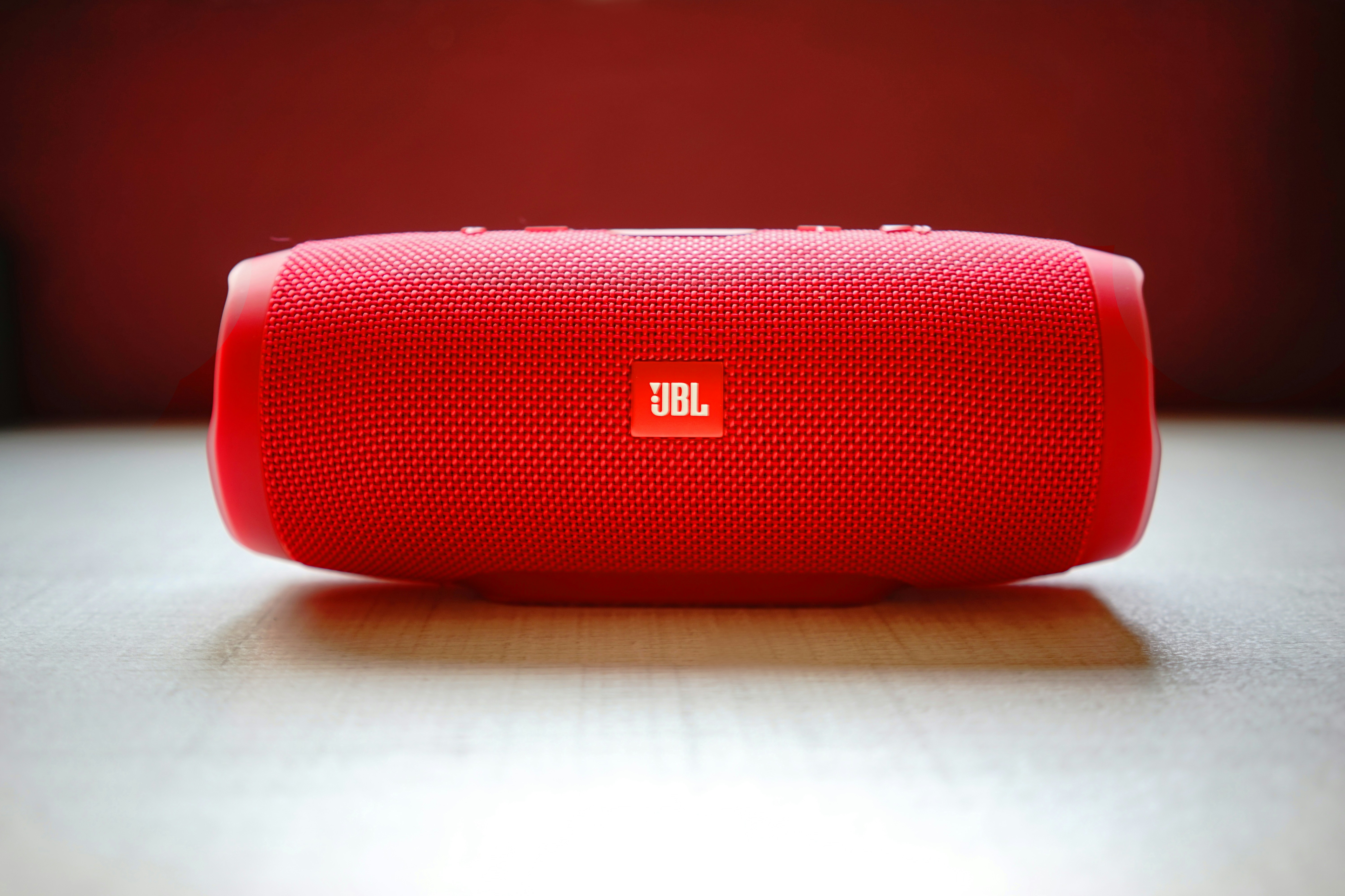 Black JBL portable bluetooth speaker on wooden surface