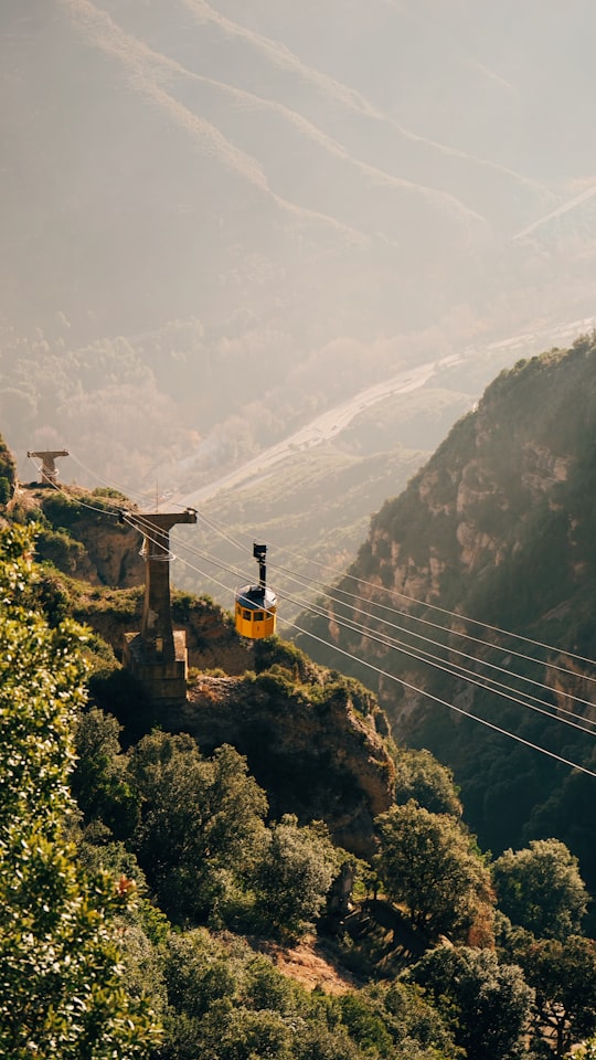 yellow cable car crossing mountains in Montserrat Spain