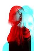 A stylized double exposure image of a person with long hair, featuring overlapping red and cyan color filters creating a ghostly effect. The person is partially facing sideways while another version of their face looks straight ahead, giving an impression of movement or duality.