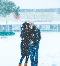 man and woman standing on snowing surface