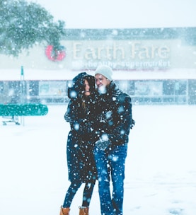 man and woman standing on snowing surface