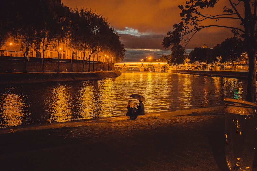 person sitting near pond