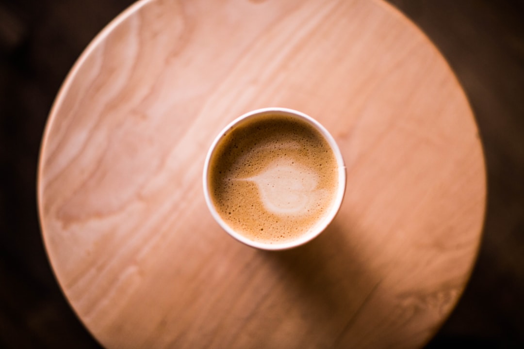 top view photo of brown ceramic mug with coffee