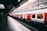 white and red train beside building at daytime