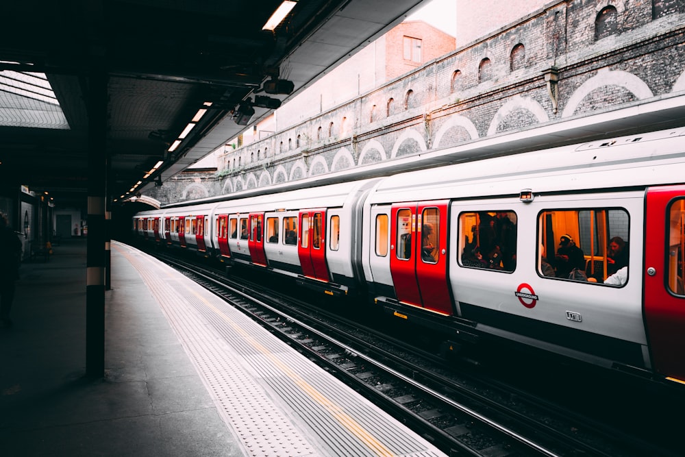 white and red train beside building at daytime