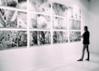 person looking at gallery art pieces on wall