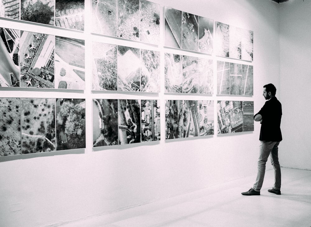 person looking at gallery art pieces on wall
