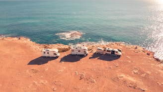 three white RV parks near sea at daytime