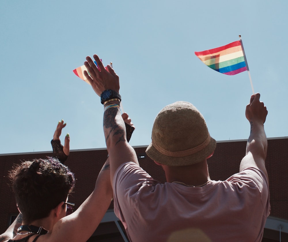 Mann hält Flagge und hebt Hände