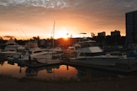 A classic used boat docked at a marina with the sunset casting warm hues over Surf City.