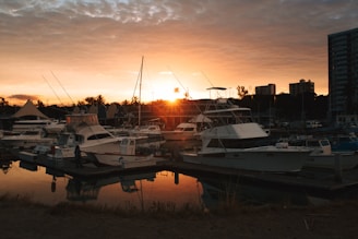 A classic used boat docked at a marina with the sunset casting warm hues over Surf City.