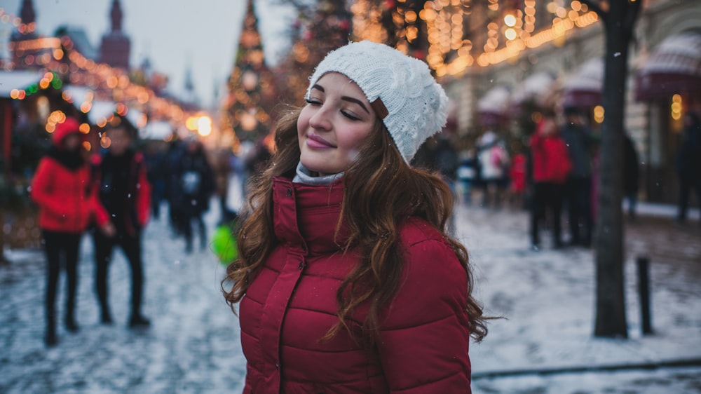 selective focus photography of woman wearing red parka jacket while standing