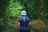 person in blue shirt walking between bamboo trees