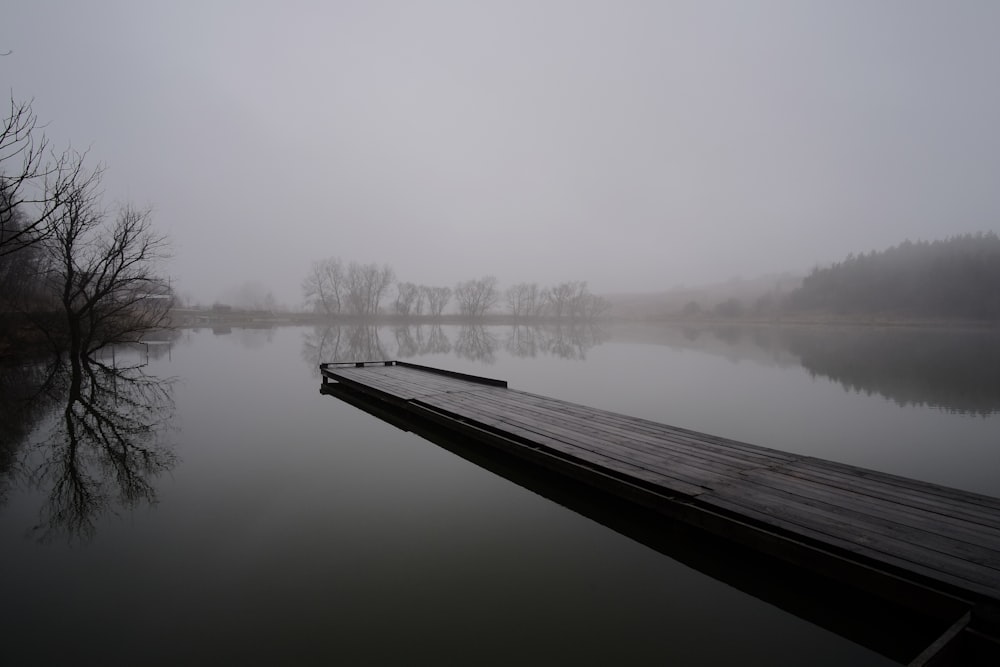 brown bridge over body of water with fogs