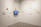 A minimalist gallery wall featuring varied image sizes and a sleek embedded video screen.