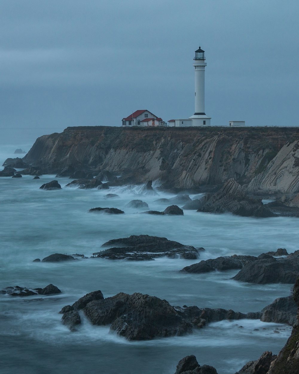 house beside lighthouse near body of water