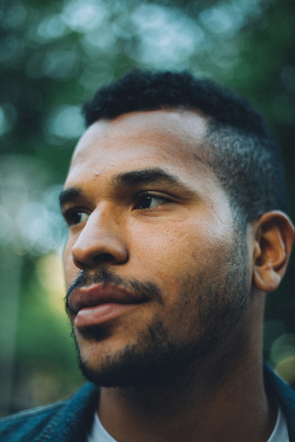 bokeh photography of man wearing blue top