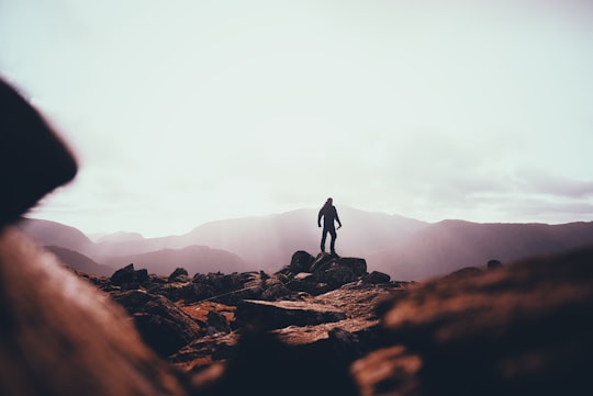 person standing on huge rock in Lake District National Park United Kingdom