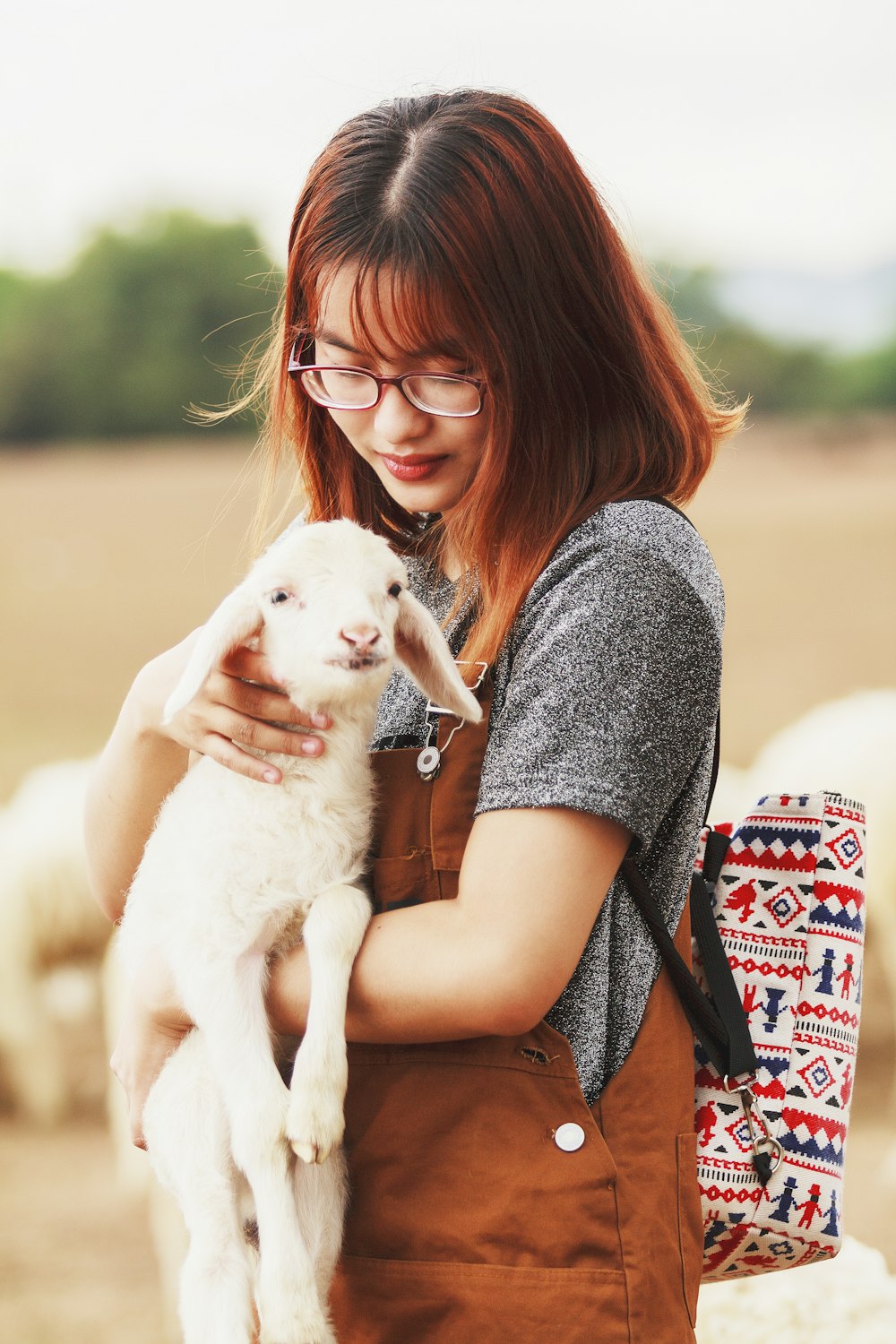 woman carrying a goat