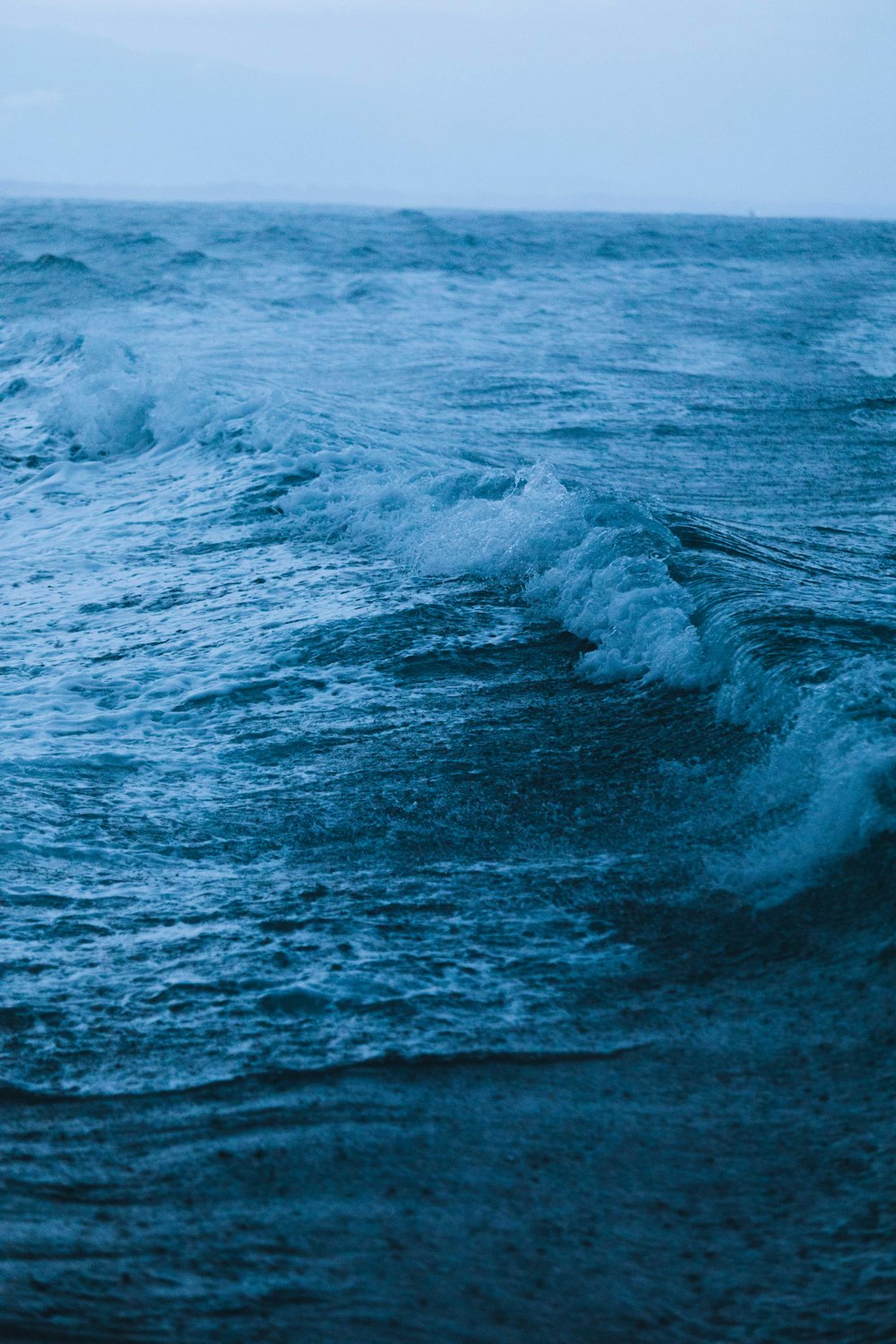 Fotografía de ángulo bajo de las olas rompiendo durante la lluvia