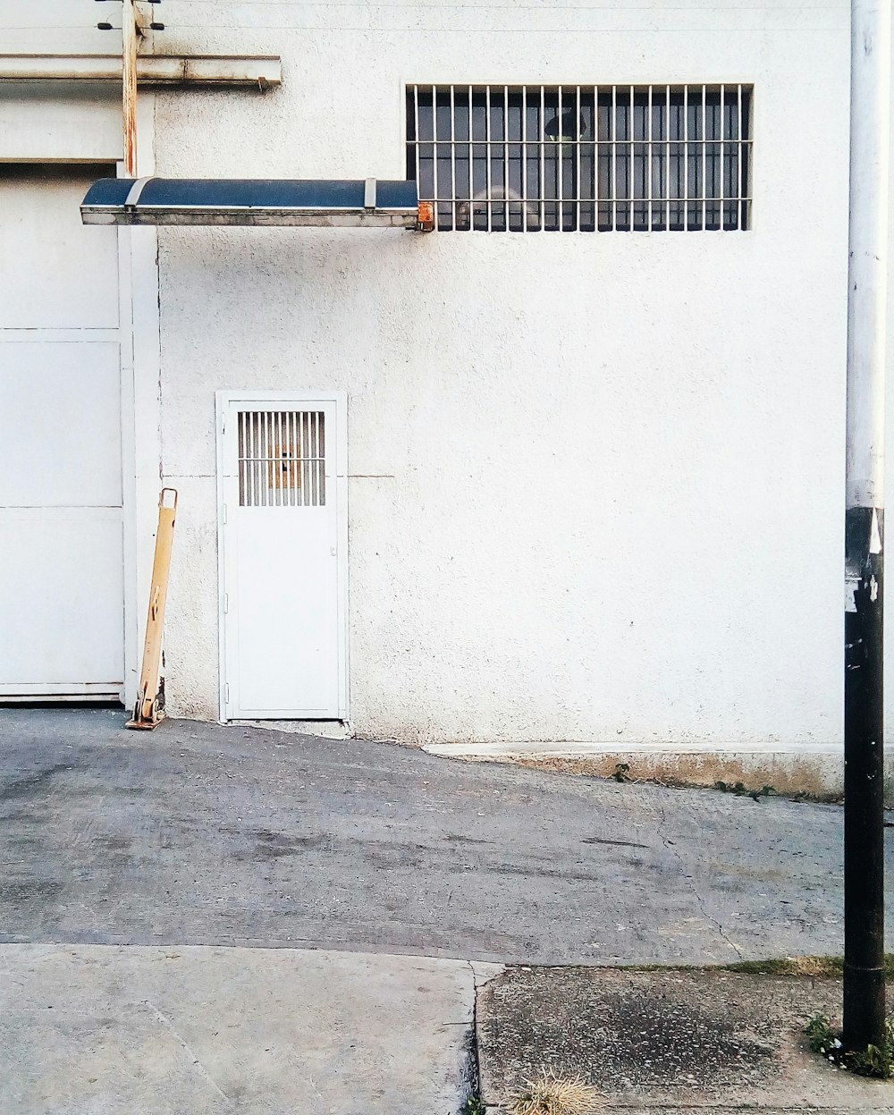 white metal closed door near road at daytime