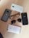 The image displays several smartphones, glasses, and sunglasses arranged on a wooden surface. The phones include brands like Motorola, Oppo, and Vivo.