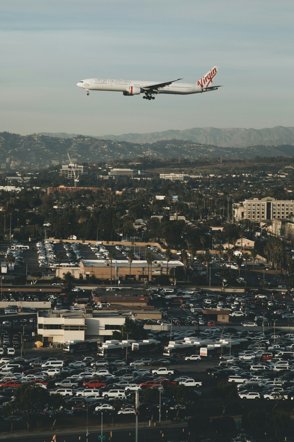 airplane over buildings and vehicles at daytime