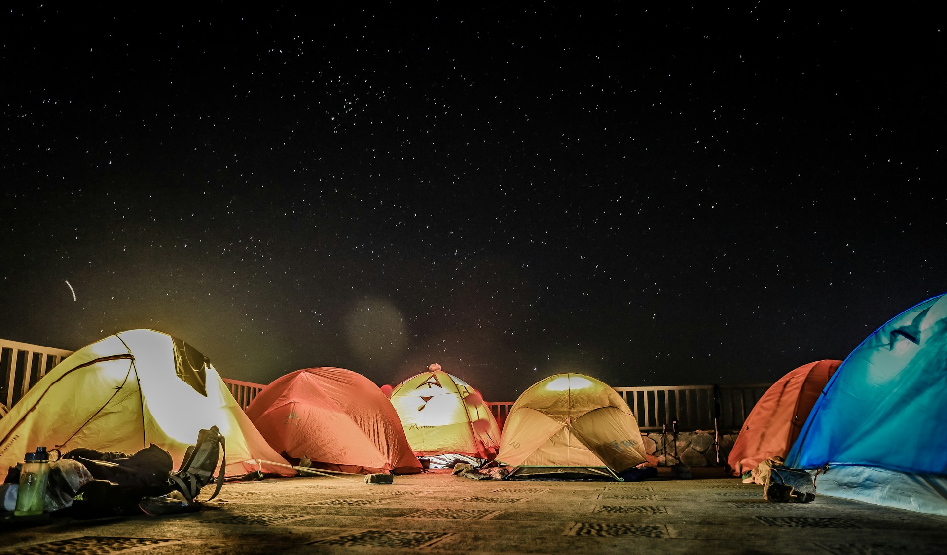 assorted-color dome tents beside fence