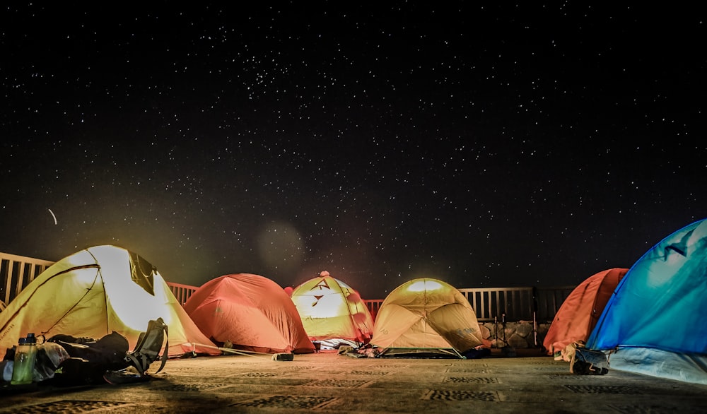 assorted-color dome tents beside fence