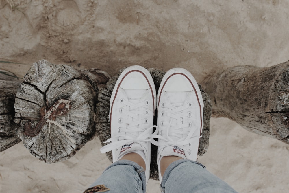 persona che indossa scarpe da ginnastica Converse All Star bianche