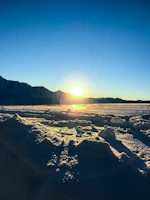 Sunrise casting golden light over the snow-capped peaks surrounding šlaitas 6191.