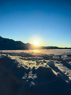 Sunrise casting golden light over the snow-capped peaks surrounding šlaitas 6191.