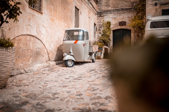 gray auto rickshaw near gray concrete wall in Matera Italy