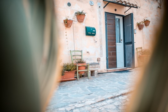 closed white and brown wooden door of white building in Matera Italy