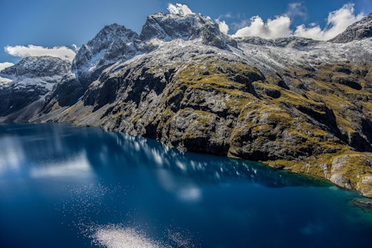 icy mountain near on body of water in Fiordland National Park New Zealand