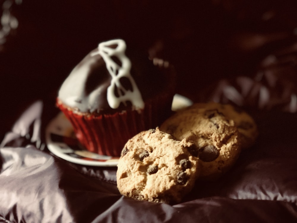 biscoitos e muffin de chocolate em tecido preto