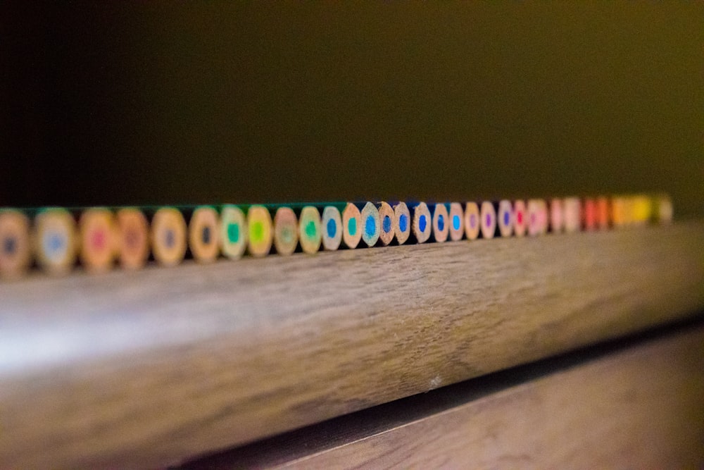 closeup photo of color pencil on brown surface