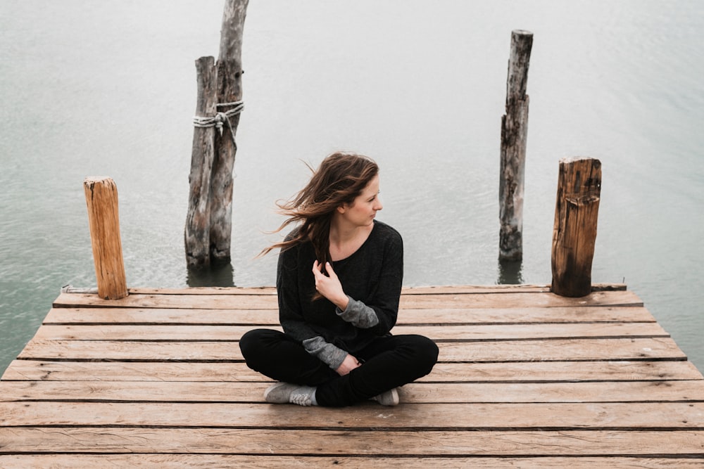 woman sitting on dock during daytime