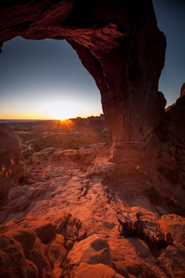 A vibrant sunset over the iconic Arch of Cabo San Lucas with tourists enjoying the view