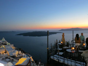 Smiling travelers enjoying the sunset over Santorini's white buildings and blue domes